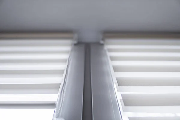 White fabric roller blinds on the white plastic window in the living room. Roll curtains indoor. — Stock Photo, Image