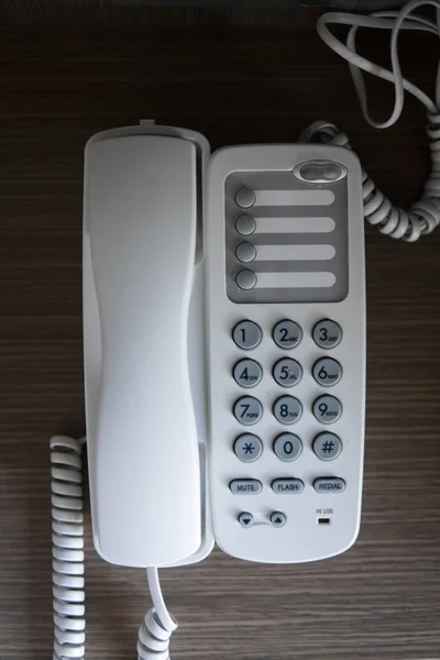 Otelde kahverengi bir masada gri coplar ile beyaz vintage telefon. — Stok fotoğraf