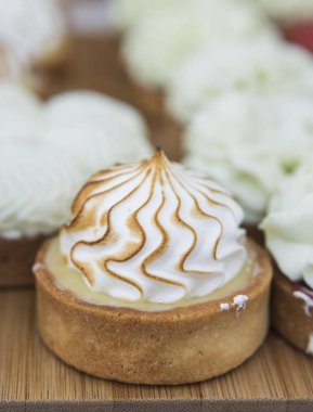 Arka plan renkli kek ve tatlılar ile dolu. Krema, çikolata ve çilek ile çeşitli farklı mini kek.