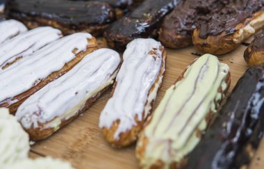 Arka plan renkli kek ve tatlılar ile dolu. Krema, çikolata ve çilek ile çeşitli farklı mini kek.