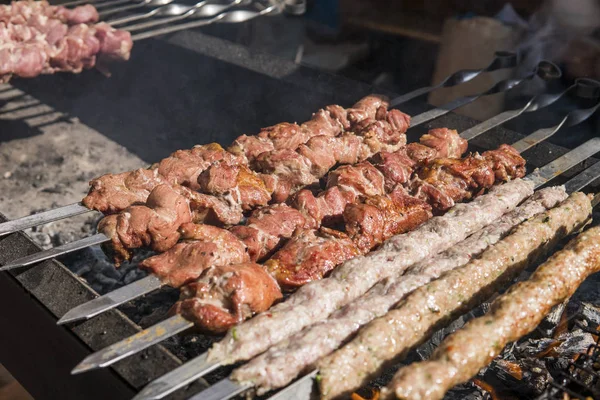 Delizioso barbecue carne alla griglia sulla griglia aperta, cucina all'aperto. Festival gastronomico in città. arrostimento di cibo saporito su spiedini, food-court. Picnic estivo . — Foto Stock