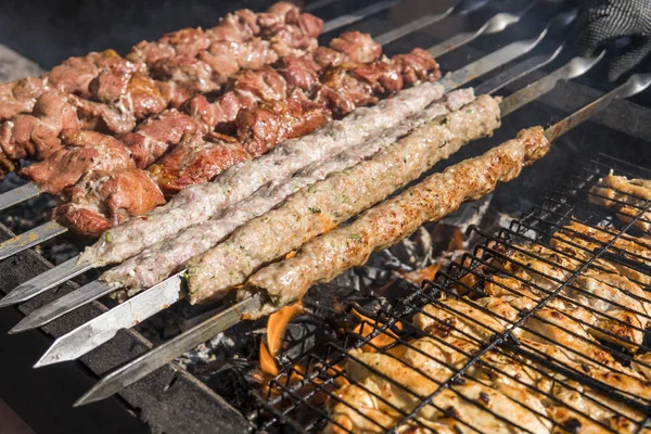 Delizioso barbecue carne alla griglia sulla griglia aperta, cucina all'aperto. Festival gastronomico in città. arrostimento di cibo saporito su spiedini, food-court. Picnic estivo . — Foto Stock