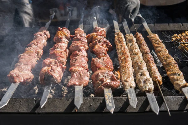 Delicious bbq grilling meat on open grill, outdoor kitchen. Food festival in city. tasty food roasting on skewers, food-court. Summer picnic. — Stock Photo, Image
