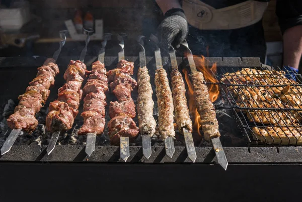 Delizioso barbecue carne alla griglia sulla griglia aperta, cucina all'aperto. Festival gastronomico in città. arrostimento di cibo saporito su spiedini, food-court. Picnic estivo . — Foto Stock