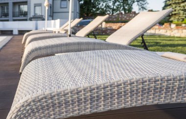 Güneşli bir günde temiz su ile havuz yakınında Şezlong.