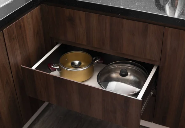 Macetas cromadas de metal en un cajón en una cocina moderna . — Foto de Stock