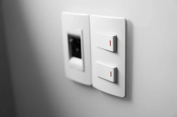 Weißer Schalter an weißer Wand mit zwei Schaltern und einem gemeinsamen Schalter. — Stockfoto