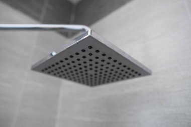 Modern bir banyoda kare duş başlığı. Banyoda su spreyi ya da suyla duş al. Rahatlayın ve banyoda keyfinize bakın. Duş başlığından temiz su akıntısı kirli bedeni temizlemek için..