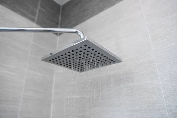 Vatten rinner från torget duschhuvud i ett modernt badrum. Dusch i badrummet med vattenspray eller vatten. En ström av sötvatten från duschmunstycket för att rengöra den smutsiga kroppen. — Stockfoto