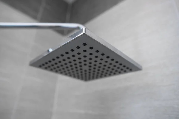Pommeau de douche carré dans une salle de bain moderne. Douche dans la salle de bain avec jet d'eau ou d'eau. Sentez-vous détendu et profiter dans la salle de bain. Un jet d'eau fraîche de la pomme de douche pour nettoyer le corps sale . — Photo
