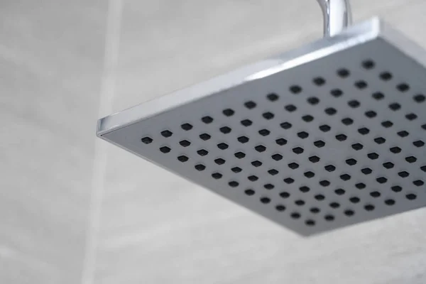 Fyrkantigt duschhuvud i ett modernt badrum. Dusch i badrummet med vattenspray eller vatten. Känn dig avslappnad och njut i badrummet. En ström av sötvatten från duschmunstycket för att rengöra den smutsiga kroppen. — Stockfoto