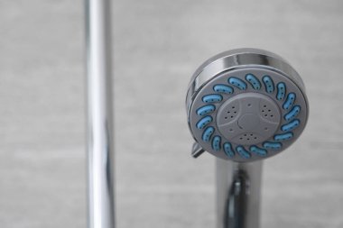 Modern banyoda modern duş başlığı. Banyoda su püskürtme veya su akışı olan duş başlığı. Rahatlamak ve özel banyoda eğlenmek. Bedenini temizlemek için duş başlığından taze su akıyor..