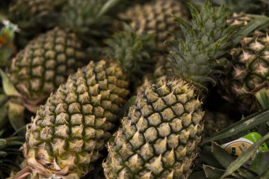 Asya 'da bir markette bir sürü ananas meyvesi. Ananasların doku arkaplanı. Tropikal ve egzotik meyveler. Sağlıklı ve vitaminli gıda kavramı.