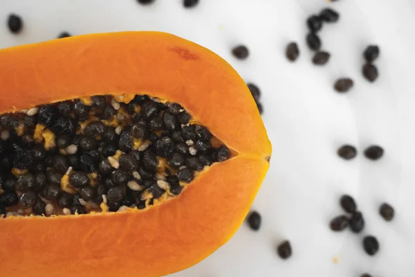 Half cut ripe papaya with seed on a white plate. Slices of sweet papaya with a white background. Halved papayas. Healthy exotic fruits. Vegetarian food. — ストック写真