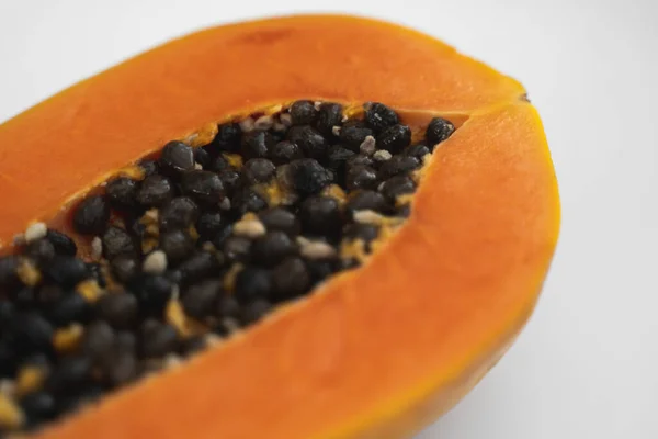 Half cut ripe papaya with seed on a white plate. Slices of sweet papaya with a white background. Halved papayas. Healthy exotic fruits. Vegetarian food. — ストック写真