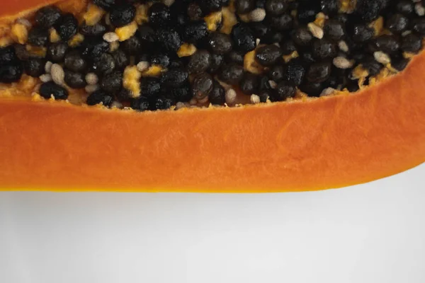 Half cut ripe papaya with seed on a white plate. Slices of sweet papaya with a white background. Halved papayas. Healthy exotic fruits. Vegetarian food. — ストック写真