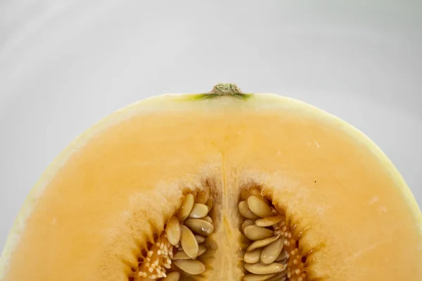 Fresh sweet orange melon on the white plate as a background with a selective focusing. Useful and vitamin-rich food. Vegeterian. — ストック写真