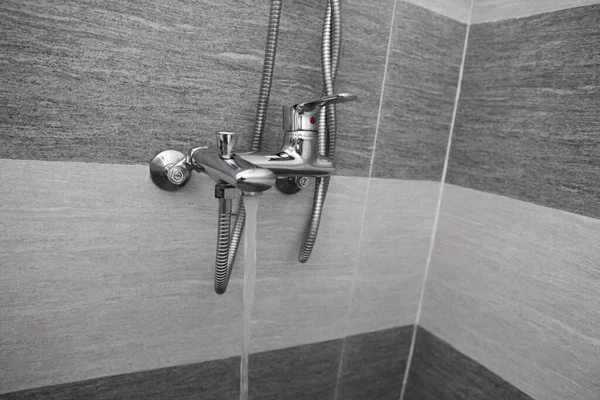 Karıştırıcıdan su akıyor. Modern tasarımcı banyoda banyo yapıyor. Krom duş, musluk banyoda, dekoratif seramik kaplı. Karıştırıcı soğuk sıcak su. — Stok fotoğraf