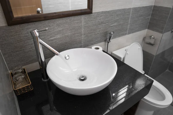 Modern bir banyoda beyaz yuvarlak lavabo ve krom musluğu olan bir banyo.. — Stok fotoğraf