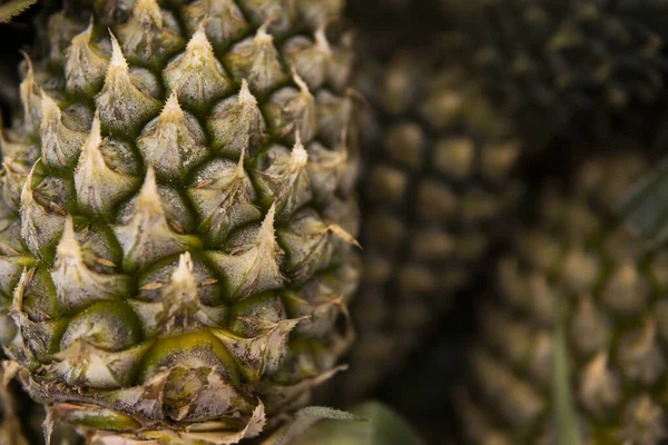 Um monte de frutas de abacaxi em um mercado no país asiático. Textura de fundo dos abacaxis. Frutos tropicais e exóticos. Conceito alimentar saudável e vitamínico . — Fotografia de Stock