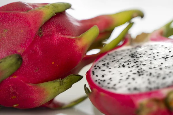 Dragon fruit. Vibrant Dragon Fruit on white background. Sliced white dragon fruit or pitaya on white plate on the table, close-up. Tropical and exotic fruits. Healthy and vitamin food concept.