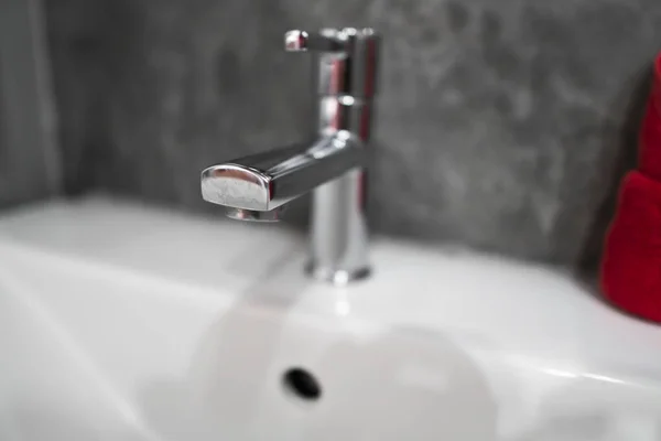 Moderní vodovod z nerezové oceli s umyvadlem umyvadla se dvěma červenými ručníky. Současný interiér koupelny. Přepychová a Stylová koupelna s betonovými zdmi stylu. — Stock fotografie