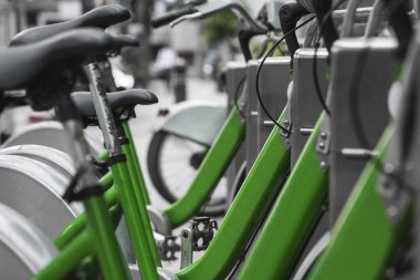 Sokak taşımacılığı yeşil hibrit bisikletler ve şehirde dolaşmak için elektronik ödeme formu kiralık ağ otoparkında sıra bekleyip bisikletçilerin bisiklet yolculuğu yapmasını bekliyor..