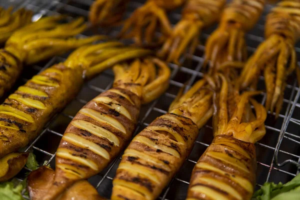 Tintahal grill forró faszén forró tűz ízletes finom tengeri étel. Grillezett tintahal nagy tűzön. Thai street food az éjszakai piacon. — Stock Fotó