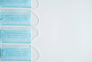 Gri arka planda tıbbi koruyucu maskeler. Koronavirüsü önlemek için ağzı ve burnu kapamak için 3 katlı tıbbi maske. Coronavirus karantinası. Covid-19 'u korumak için antivirüs tıbbi maskesi.