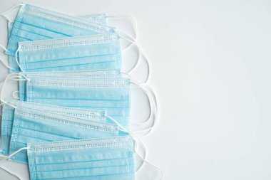 Gri arka planda tıbbi koruyucu maskeler. Koronavirüsü önlemek için ağzı ve burnu kapamak için 3 katlı tıbbi maske. Coronavirus karantinası. Covid-19 'u korumak için antivirüs tıbbi maskesi.
