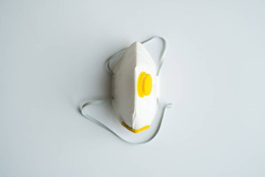 Solunum maskesi, ağzı ve burnu kaplayan toz maskesi ve gri arka planda izole edilmiş koronavirüsü önler. Hava kirliliği, grip ve koronavirüsten korunma.