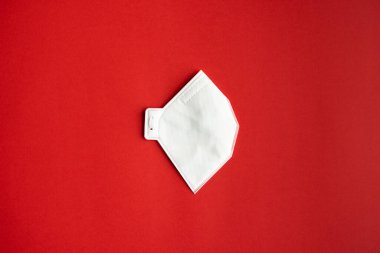 Solunum maskesi veya toz maskesi ağız ve burun için kırmızı arka planda izole edilmiş koronavirüsü önler. Hava kirliliği, grip ve koronavirüsten korunma.