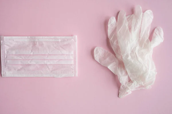 Máscara de proteção médica e luvas de borracha estão em um fundo rosa. Kit de proteção antivírus contra covid-19. pandemia de Coronavirus 2019 . — Fotografia de Stock