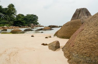 Tayland 'ın güneyindeki tropikal adada bulutlu bir günde kayalık bir sahil..