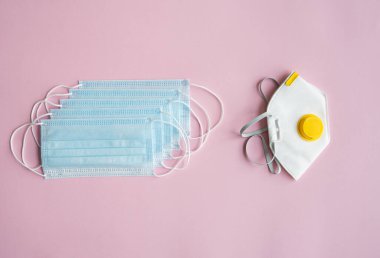 Solunum cihazı ffp ve tıbbi maskeler pembe arka planda yalan söyler. Covid-19 'a karşı anti-virüs koruma kiti. Coronavirus salgını 2019.