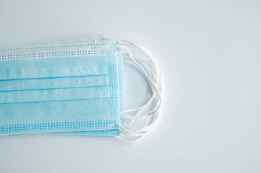 Gri arka planda tıbbi koruyucu maskeler. Koronavirüsü önlemek için ağzı ve burnu kapamak için 3 katlı tıbbi maske. Coronavirus karantinası. Covid-19 'u korumak için antivirüs tıbbi maskesi.