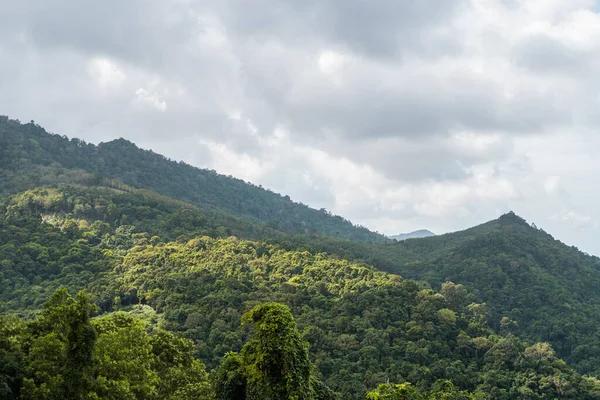 Nyári trópusi erdős dombok felhős égbolttal. Hegyek és fehér felhők a kék égen. Trópusi nyaralás koncepció. — Stock Fotó