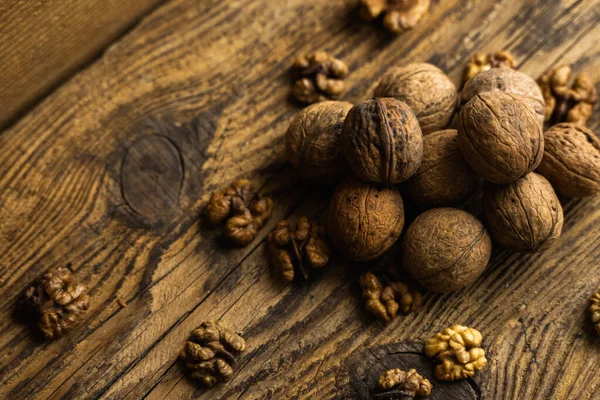 Noz espalhada na mesa vintage de madeira. Nozes é uma proteína vegetariana saudável alimento nutritivo. Noz em madeira velha rústica . — Fotografia de Stock