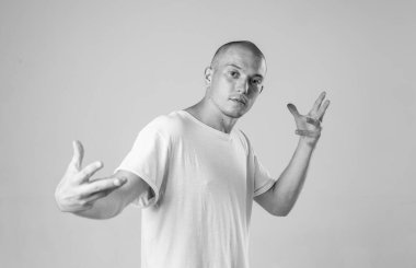 Beyaz arka planda siyah beyaz tişörtlü Bboy 'un modern destansı siyah beyaz portresi. Breakdance ve hiphop dansçısı. Gizemli ve havalı.