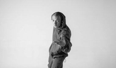 Bir hip hop dansçısı ya da bboy beyaz arka planda bir pozda donar. Bboy şık numaralar yapıyor..