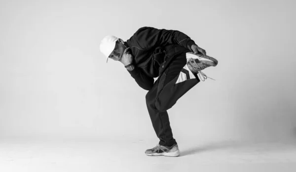 Un uomo ballerino hip hop o bboy si blocca in una posa su uno sfondo bianco. ragazzo facendo elegante acrobazie . — Foto Stock