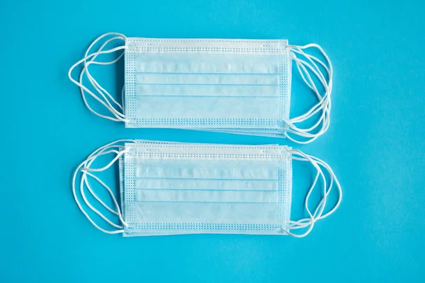 Medische maskers op een blauwe achtergrond. Wegwerp 3-laags medisch masker om de mond en neus te bedekken om coronavirus te voorkomen. Coronavirus quarantaine. Antivirus medisch masker voor bescherming covid-19. — Stockfoto