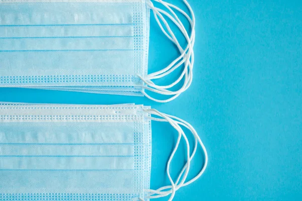 Máscaras de proteção médica em um fundo azul. Máscara médica descartável de 3 camadas para cobrir a boca e o nariz para prevenir o coronavírus. Quarentena do Coronavírus. Máscara médica antivírus para proteção covid-19 . — Fotografia de Stock