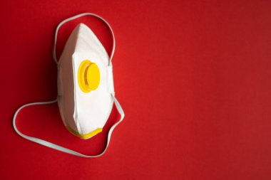 Solunum maskesi veya toz maskesi ağız ve burun için kırmızı arka planda izole edilmiş koronavirüsü önler. Hava kirliliği, grip ve koronavirüsten korunma.