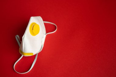 Solunum maskesi veya toz maskesi ağız ve burun için kırmızı arka planda izole edilmiş koronavirüsü önler. Hava kirliliği, grip ve koronavirüsten korunma.