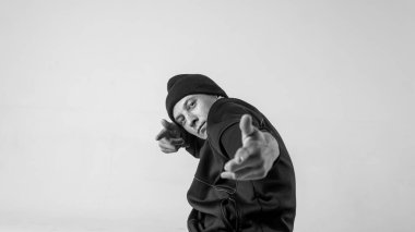 Beyaz arka planda siyah-beyaz modern destansı bboy portresi. Breakdance ve hiphop dansçısı. Gizemli ve havalı.