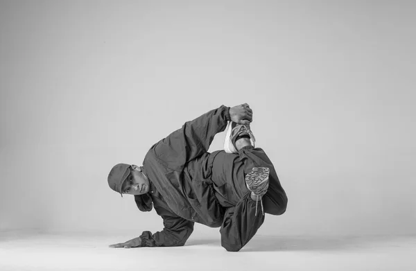 Ein männlicher Hip-Hop-Tänzer oder Bboy erstarrt in einer Pose auf weißem Hintergrund. Bboy macht stylische Stunts. — Stockfoto