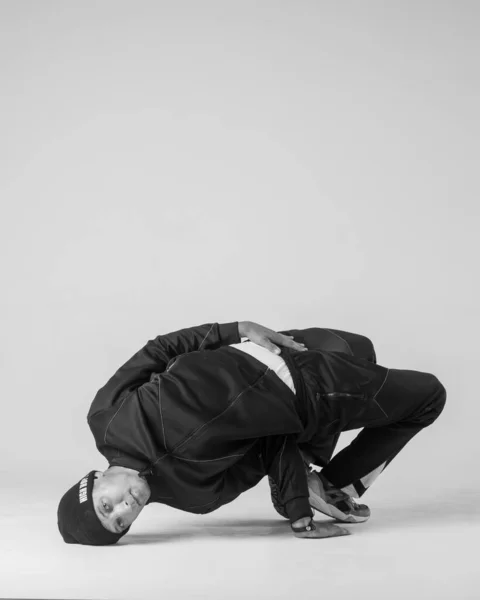 Ein männlicher Hip-Hop-Tänzer oder Bboy erstarrt in einer Pose auf weißem Hintergrund. Bboy macht stylische Stunts. — Stockfoto