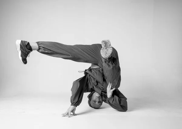 Un uomo ballerino hip hop o bboy si blocca in una posa su uno sfondo bianco. ragazzo facendo elegante acrobazie . — Foto Stock