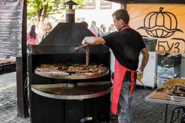 UKRAINE, LUTSK - 5 Haziran 2019: Adam yemek festivalinde domuz pirzolası pişiriyor.